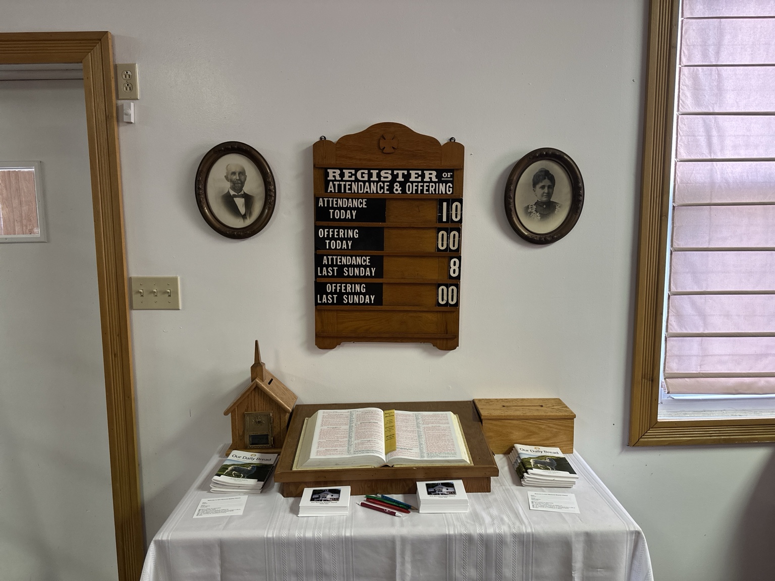Karl and Elizabeth Grahn’s portraits beside the church attendance register